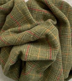 a green and red checkered blanket laying on top of a bed