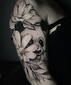 a woman's arm with a panda bear and flowers on it