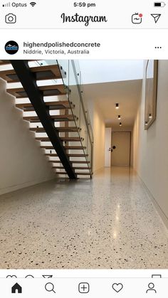 an empty hallway with marble flooring and wooden staircase leading up to the second floor