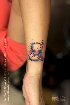 an elephant tattoo on the wrist is shown in blue and pink watercolors,