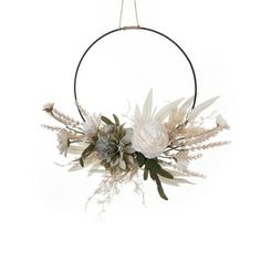 a white flower wreath hanging from a metal hoop