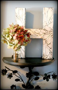 a flower arrangement sits on top of a table in front of a letter shaped sign