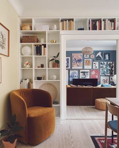 a living room filled with furniture and bookshelves next to a dining room table