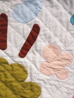 a quilted wall hanging with different shapes and colors