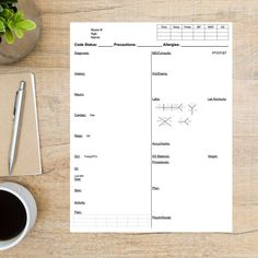 a blank workbook next to a cup of coffee and a pen on a wooden table