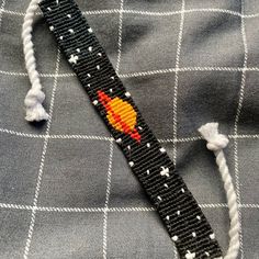 a black and white tie with an orange rocket ship on it's back end