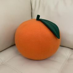 an orange sitting on top of a white couch