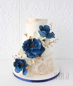 a white and blue wedding cake with flowers on it