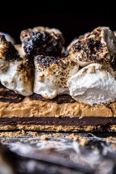 chocolate cake with marshmallows and other toppings on the top, in front of a black background