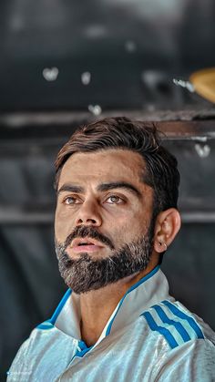 a man with a goatee and beard is looking up at the sky in front of him