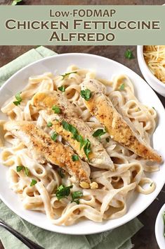 chicken fettuccine alfredo on a white plate with green garnishes