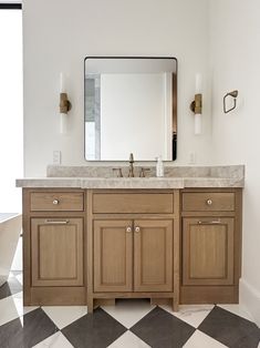 a bathroom with a checkered floor and large mirror