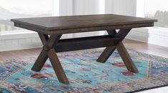 a wooden table sitting on top of a blue rug