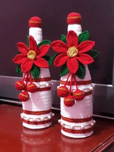 two knitted vases with poinsettias on them sitting on a table