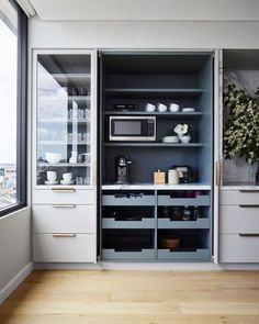 a kitchen with white cabinets and gray walls