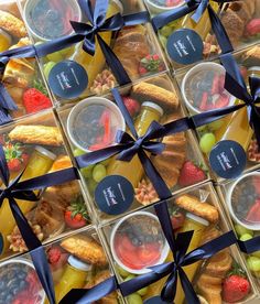 a box filled with lots of different types of food next to a blue ribbon tied around it