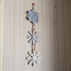 a snowflake hanging from the side of a wall next to a clock on a chain