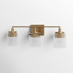 three light brass bathroom fixture with frosted glass shades on the sides and gold fixtures