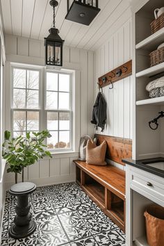 a white and black tiled floor in a room with a bench, potted plant and coat rack