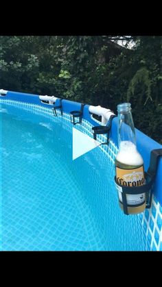 a beer bottle sitting on the edge of a swimming pool