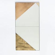 a mirror that is sitting on top of a wooden table with white and gold accents