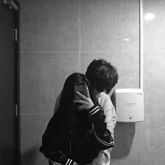 a person taking a selfie in front of a urinal with a red heart on it