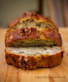 a loaf of banana nut bread sitting on top of a wooden cutting board