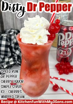 a red drink with whipped cream and cherries in it next to a can of dr pepper