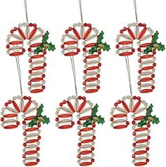 six red and white christmas decorations hanging from clothes pins