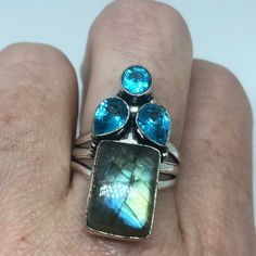 Huge very fiery Labradorite rainbow moonstone and blue topaz Lovely vintage silver setting is low content silver NOT 925 Can be re sized for you. My jeweler charges a $10-$20 fee Ring is long covers from knuckle to knuckle. All rings are shipped in a nice gift box. Check out our over a THOUSAND great reviews Engraving is $4 per letter and is not always perfect depending on the piece. It can take a few days if the jeweler is busy. This is payable to Paypal Judithsltd@gmail.com Silver Topaz Ring With Moonstone Gemstone, Spiritual Silver Topaz Gemstone Ring, Spiritual Silver Topaz Ring, Silver Multi-stone Moonstone Ring In Spiritual Style, Blue Topaz Silver Ring With Stones, Unique Silver Topaz Gemstone Ring, Silver Blue Topaz Ring With Stones, Spiritual Silver Multi-stone Moonstone Ring, Silver Topaz Ring For Jewelry Making