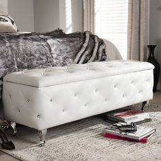 a white bench sitting on top of a rug next to a bed in a bedroom