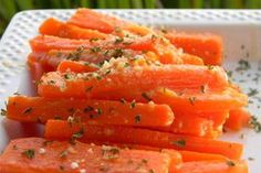 sliced carrots on a white plate with herbs