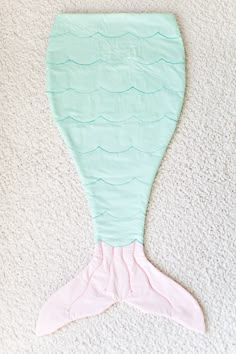 an image of a mermaid tail made out of fabric on the floor with text that reads,