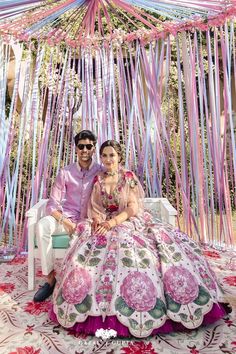 a man and woman sitting on a couch in front of a decorated stage with streamers