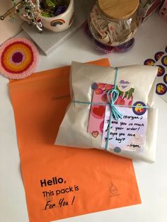 an orange envelope with a note attached to it next to some other items on a table