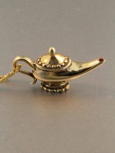 This whimsical Magic Lamp charm comes complete with three wishes, so use them wisely! It is pictured here in 14K gold with a ruby set in the tip of the lamp.The gold chain is not included in the price. If you would like a solid 14k gold chain please select the stye and length from the option menu. If you would prefer a different style or length please contact us.All Marty Magic Jewelry is packaged in a beautiful box embossed with the gold foil Marty Magic dragon logo. Perfect for any occasion!De Lamp Necklace, Gold Magic, Genie Lamp, Magic Lamp, Lamp Pendant, Gold Chain With Pendant, Luck Charm, Disney Jewelry, 14k Gold Necklace