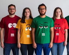 four people wearing m and m shirts with eyes