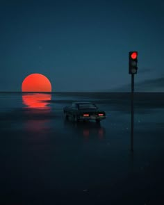 a car is parked in the water near a traffic light at night with an orange sun behind it