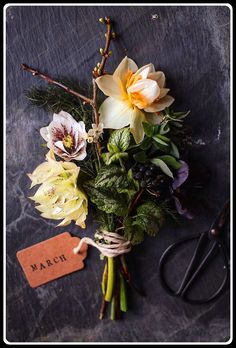 a bunch of flowers sitting on top of a table next to a pair of scissors