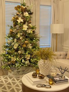 a living room with a christmas tree in the corner and decorations on the coffee table