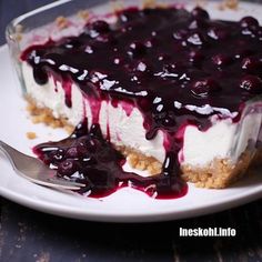 a white plate topped with a dessert covered in blueberries