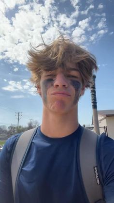 a young man with his face painted like a baseball bat and holding a baseball bat