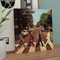 an image of the beatles album cover on a table next to a potted plant