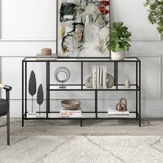 a black metal shelf with books and plants on it in a white room next to a chair