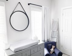 a baby's room with white walls and furniture