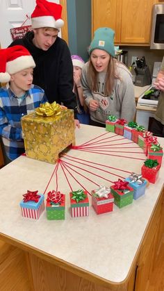 a group of people standing around a table with presents