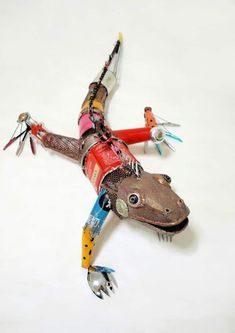 an animal made out of assorted items on a white surface with one leg up