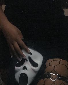 a person is holding a white mask on top of a cake that looks like a ghost