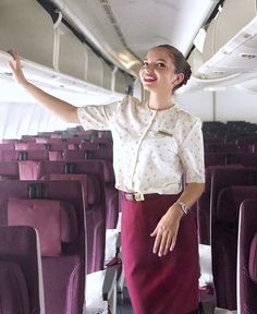 a woman standing on an airplane with her arms outstretched