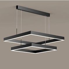 a suspended light fixture with two lights hanging from it's sides and one is black